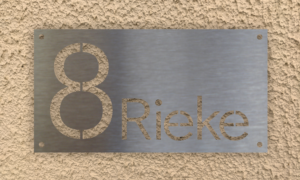 Edelstahlschild gelbe Wand