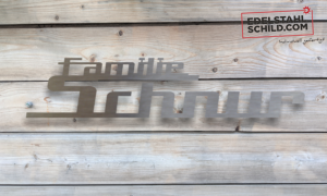 Edelstahlschild vor Holz