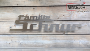 Edelstahlschild vor Holz